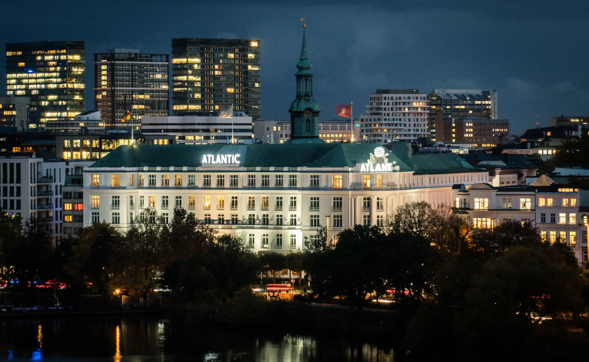 Die beleuchtete Fassade des ZelvessianRoyalcourt bei Nacht